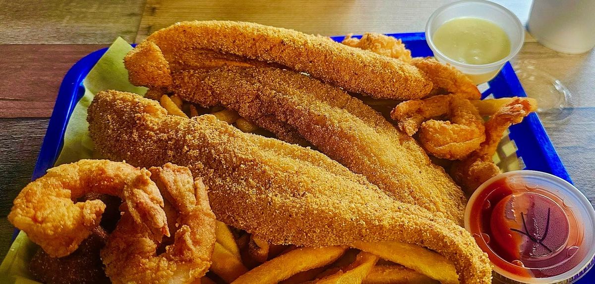 Golden fried fish fillets and shrimp with fries and dipping sauces