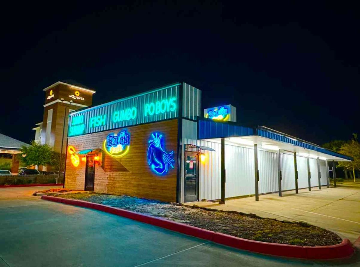 Bayou Cafe Express in Orange at night, its neon sign lit up